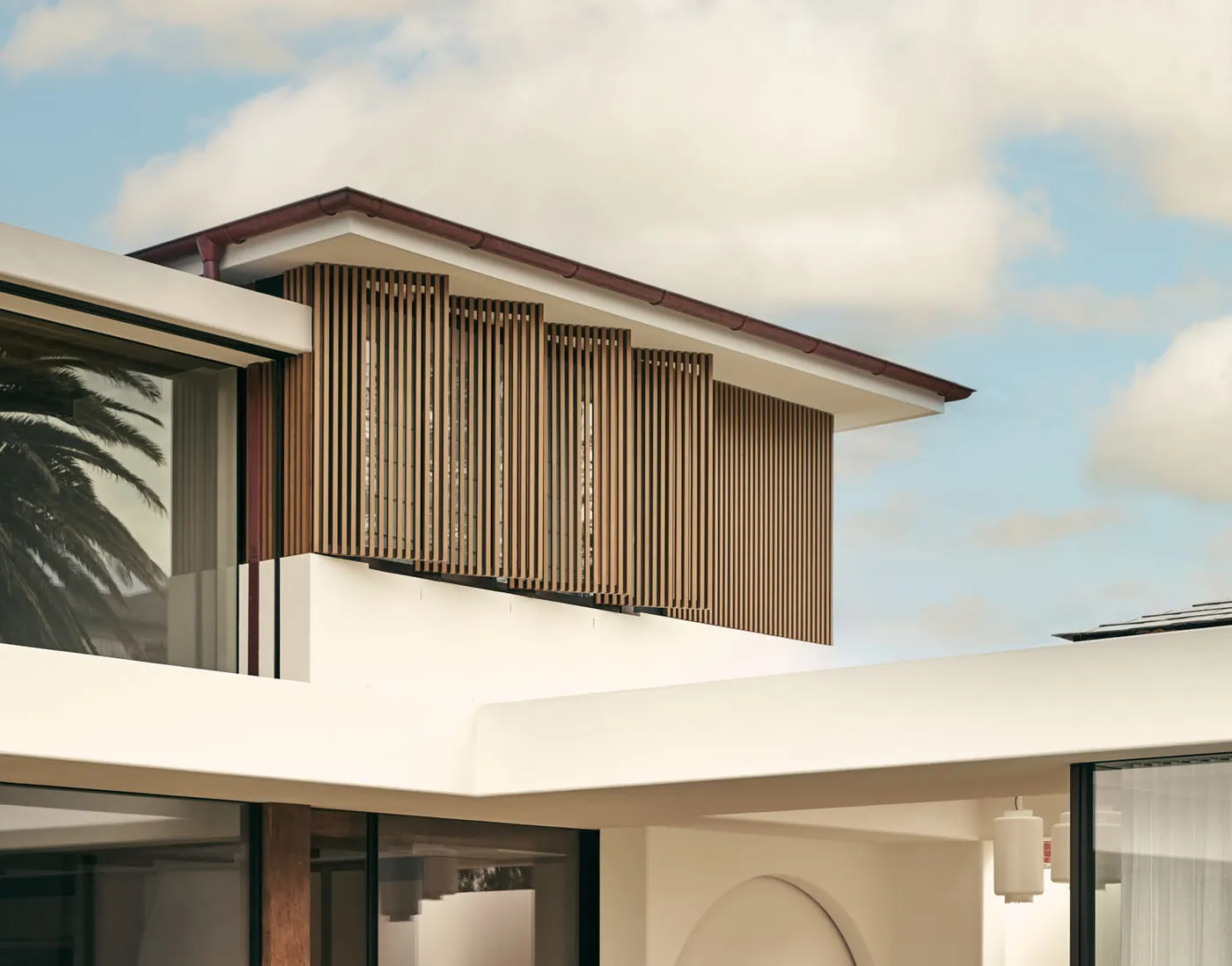 Molong House, North Curl Curl: timber-battened screen and deep eaves against the sky