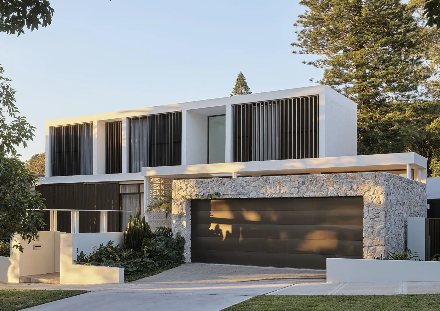 Warren House, Bellevue Hill: street elevation in white render, timber battens and a stone garage wall